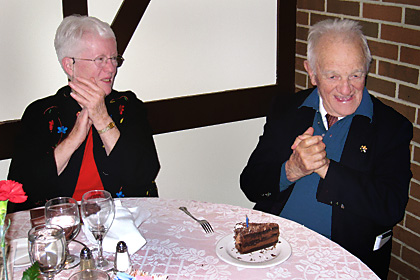 Colonel Sally Pritchett, USMC (Ret) applauding as the  slice of cake is delivered. Cy, aka The Leprechaun blows out  one candle as the fire marshall  forbid us to light 90 candles